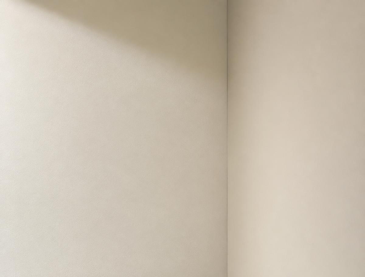 Fein verputzte Innenwand mit präziser Ecke im warmen Tageslicht